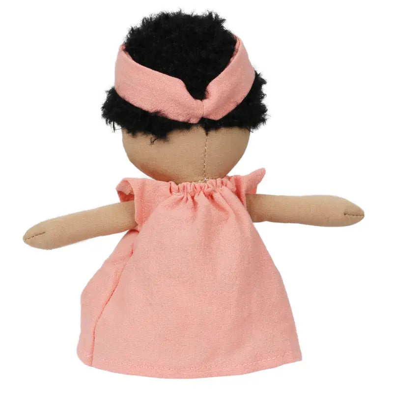The Wilbery Baby Doll Girl in a coral outfit, with curly black hair and outstretched arms, is shown from the back. Part of the charming Wilbery dolls collection.