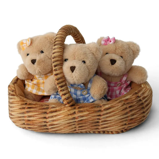The Wilberry Teddy Bears’ Picnic Soft Toy Set features three plush teddy bears in blue, yellow, and pink checkered outfits with matching ribbon bows, all sitting together in a woven picnic basket, perfect for imaginative play.