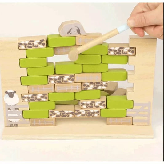 A Wobbly Wall Game "4 Friends" designed for preschoolers to resemble a wobble wall or fence, with green bricks and animal patterns, accompanied by a small wooden hammer being used to interact with the pieces.