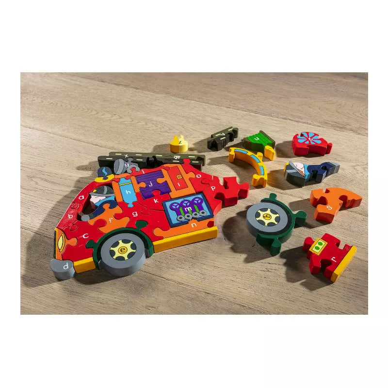 An Alphabet Jigsaws Alphabet Fire Engine surrounded by toys on a wooden floor.
