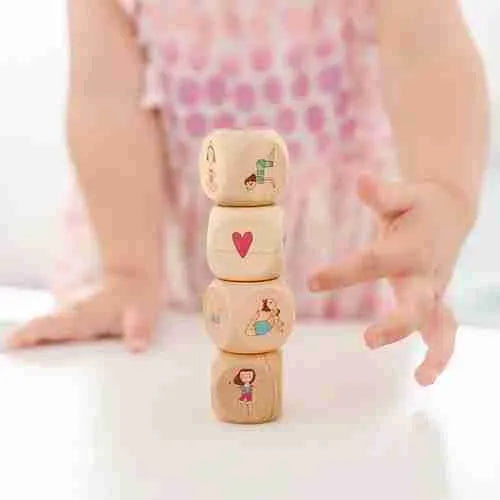 A little girl is stacking Yogi Dice on top of each other.