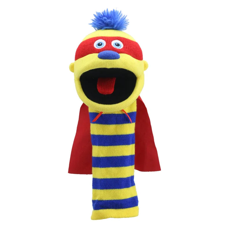 The Puppet Company Sockette Zap is a colorful knitted sock puppet with yellow and blue stripes, red mouth, blue tongue, red nose, googly eyes, blue fuzzy hair, and a red cape. Its open mouth looks ready to talk or sing.