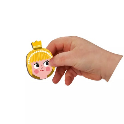A hand holding a Janod Fairy Tales Magneti’Book with a cut out of a girl's head.