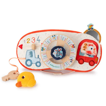 A colorful baby toy designed for interactive play and learning, featuring numbers and various textures. The Lilliputiens Farm Car Activity Panel includes a plush duck, a small plush dog in a car, and a mirror. The background is speckled white with red, blue, and yellow accents.