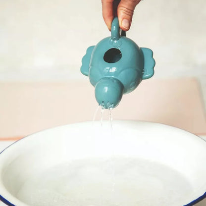 A person is pouring water from the Pablo Floating Watering Can ECO into a bowl.