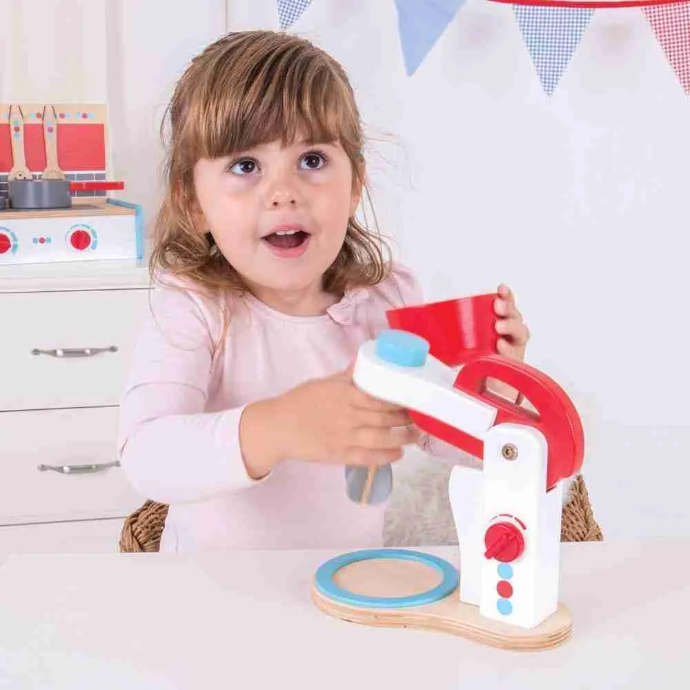 A little girl that is playing with the Bigjigs Food Mixer by Bigjigs.