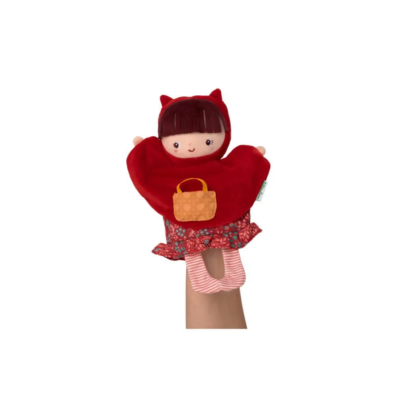 A Lilliputiens Red Riding Hood Handpuppet of a doll in a red hooded cape with small pointed ears, holding a tiny orange handbag. The doll has brown hair with bangs and wears a red and white patterned dress with striped red and white tights. Ideal for imaginative play, perfect for young children.
