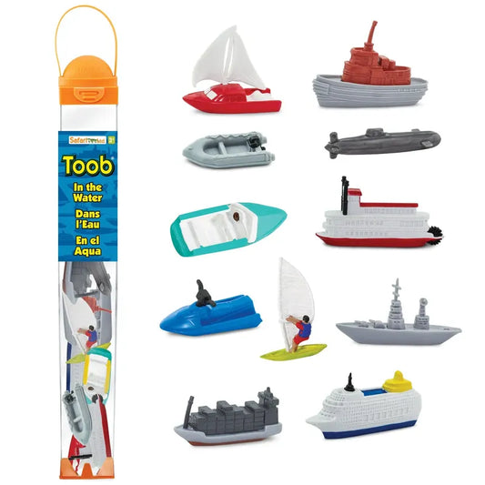 A collection of TOOB® figurines in the water, including sailboats, submarines, and a cargo ship, contained in a clear plastic tube packaging labeled "toob - in the water.