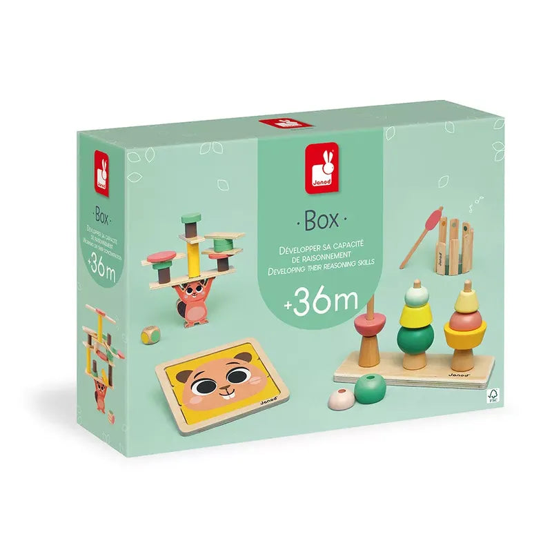 A box of Janod Box of Toys 36 Months for children aged 36 months and older. The box features various wooden toys designed to develop reasoning skills, including stacking rings, a balancing game, and a shape-sorting puzzle. The green packaging showcases these engaging developmental toys for 3-year-olds.