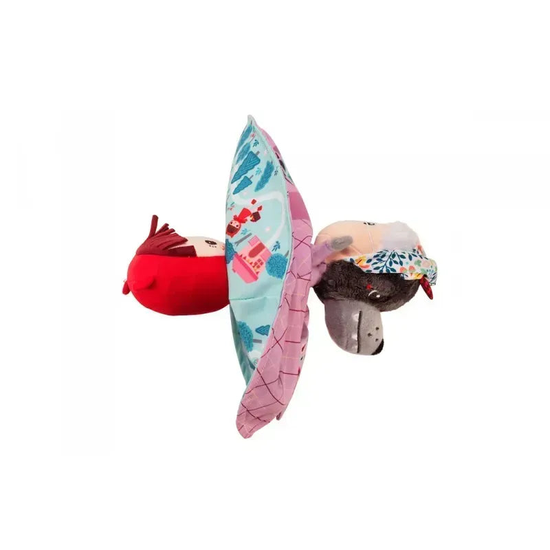 The Lilliputiens Little Red Riding Hood Reversible Storydoll is a plush, reversible hand puppet that can transform between Little Red Riding Hood in her red hood and cloak and the gray wolf in floral clothing. Featuring a pink and blue patterned seam, this storytelling toy boasts vibrant colors and soft fabric.