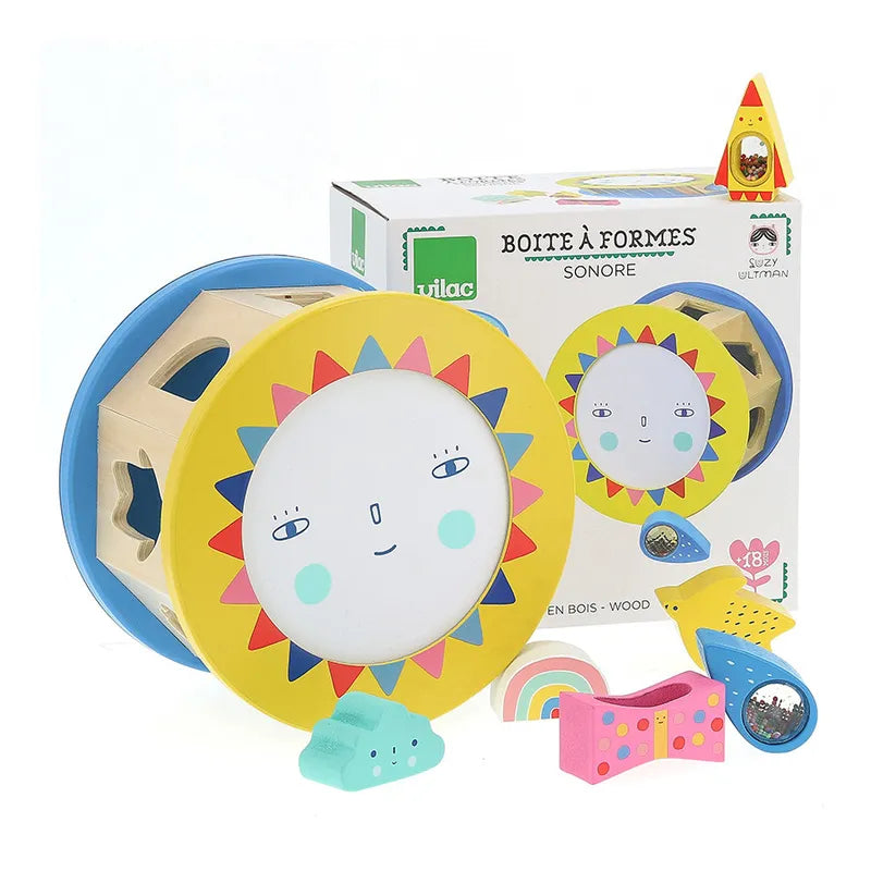 The Vilac Night and Day Shape Sorter is a colorful wooden shape sorter baby toy designed for children aged 18 months and older, featuring a sun face design on the front. The packaging displays the toy along with several brightly colored shapes, including a rainbow, house, bird, and tree—perfect for developing fine motor skills.