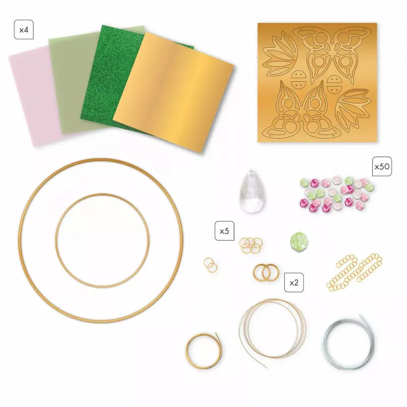 A collection of DIY craft materials, perfect for creating a Janod Suncatcher To Make, includes three different sized gold metal rings, four pieces of colored paper (two pink, one green, one gold), a cut-out template with butterfly and floral shapes, beads, wire, chain segments, and various rings and jump rings.