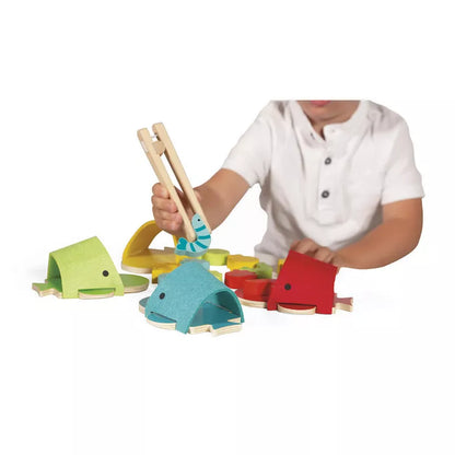 A young boy playing with Janod Whales Colour Matching Game on a white background.
