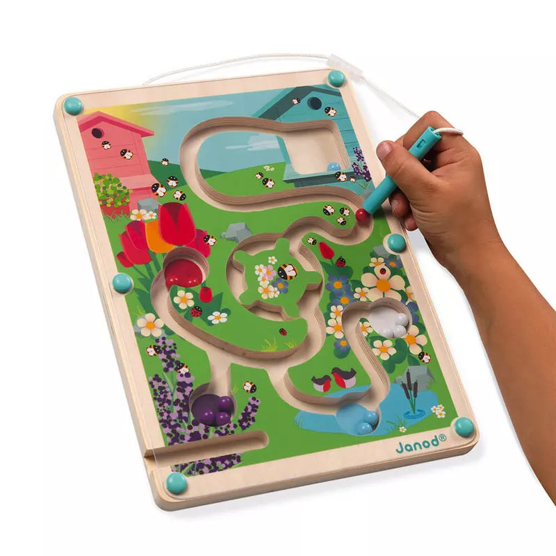 A child's hand is holding a Janod Hive Magnetic Maze.