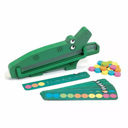 A green Djeco Educational Crococroc toy gun with candy in front of it.