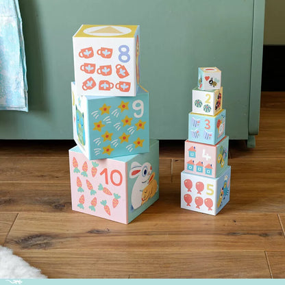 A stack of Djeco BabyBlocki blocks sitting on top of a wooden floor.