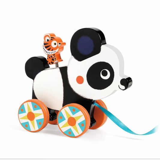 A panda bear riding a Djeco Billie Pull along Toy on a blue ribbon.