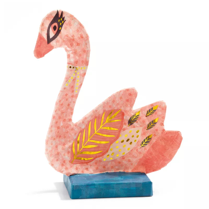 A Djeco Swan sculpture sitting on top of a blue block.