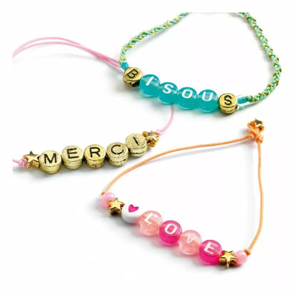 A couple of Djeco Alphabet bead bracelets that are sitting on a table.